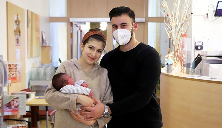 Neujahrsbaby Ilyas im Arm seiner Eltern